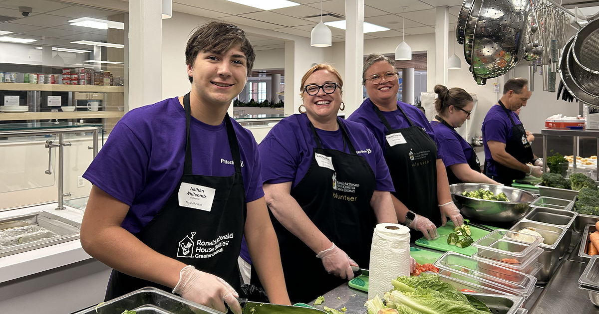 Protective employees chopping vegetables at Ronald McDonald House 