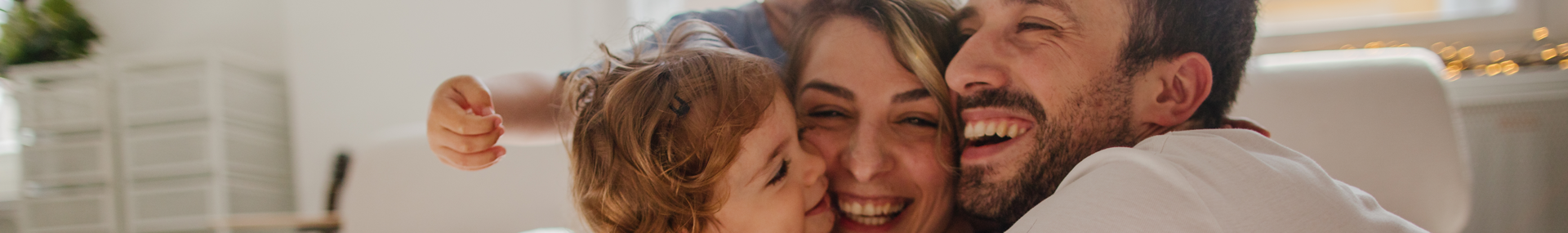 Father and mother playing with their young child indicating they are making special memories together at home.