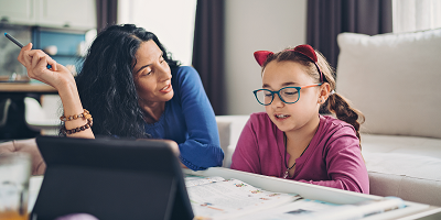 Mother helping daughter with online learning