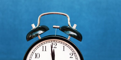 An alarm clock against a blue background.