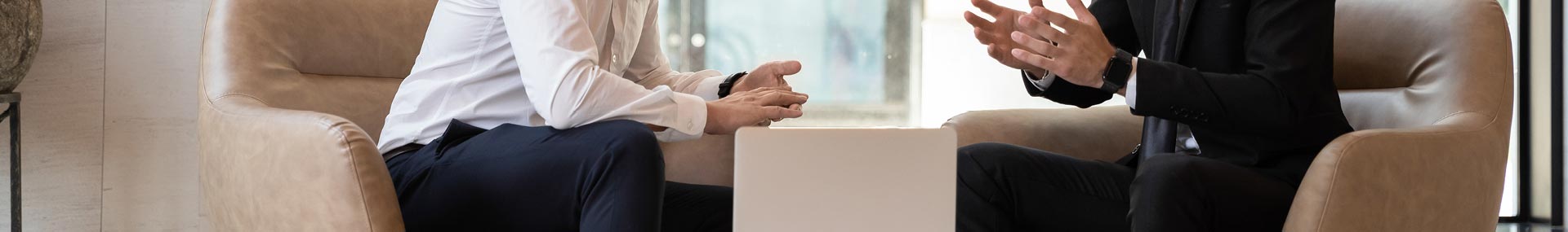 Young professional male discussing a project with a colleague in the workplace. 