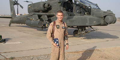 Matthew Hamilton, U.S. Army veteran and Head of HR Strategy and People Analytics at Protective, standing next to helicopter