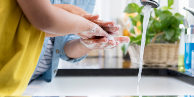 A mother helping her child wash their hands to avoid getting the flu. 