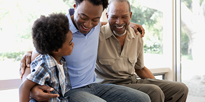 Three generations of men sit and laugh together