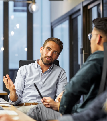 Two men in a conference room at their workplace.