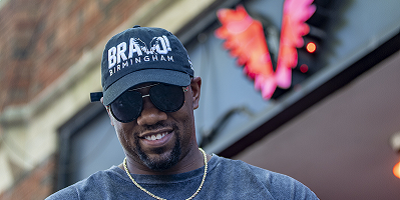 Andrew Jones smiling in front of Fly V office wearing Protective Stadium hat