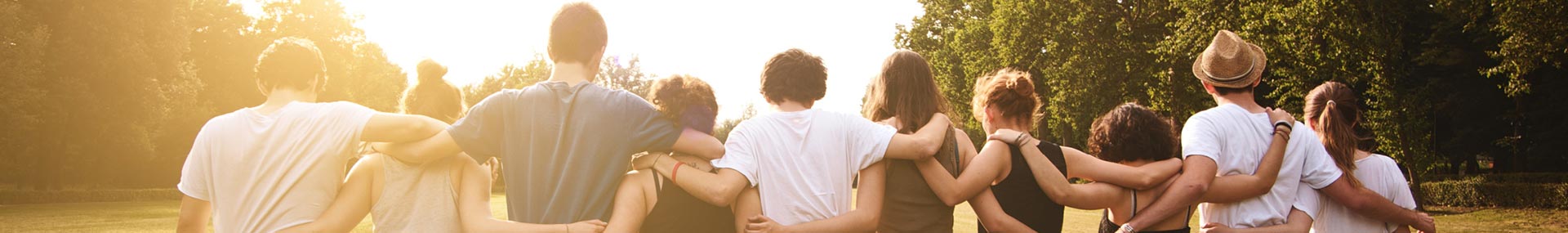 A team of young volunteers walking with their arms linked. 