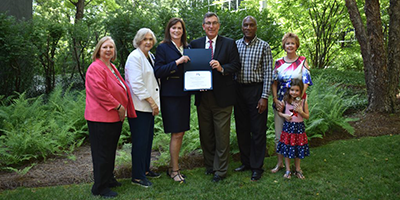 Protective Life CEO and others present the flag certificate from the girl scout troops.