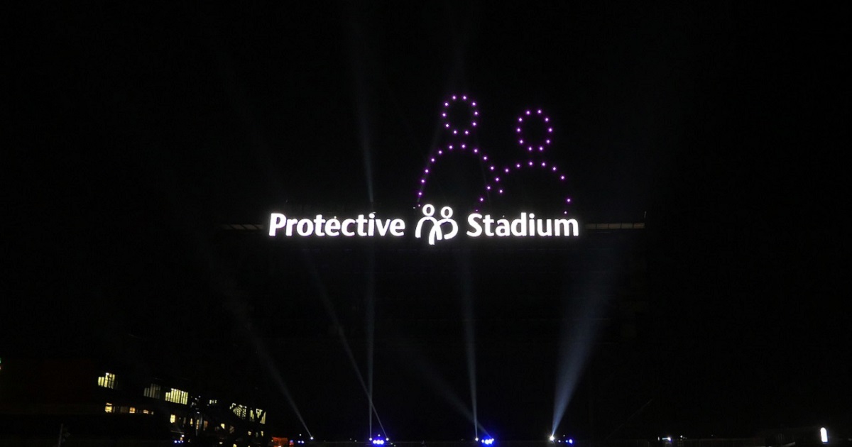 Protective Stadium sign lit with drone symbol behind